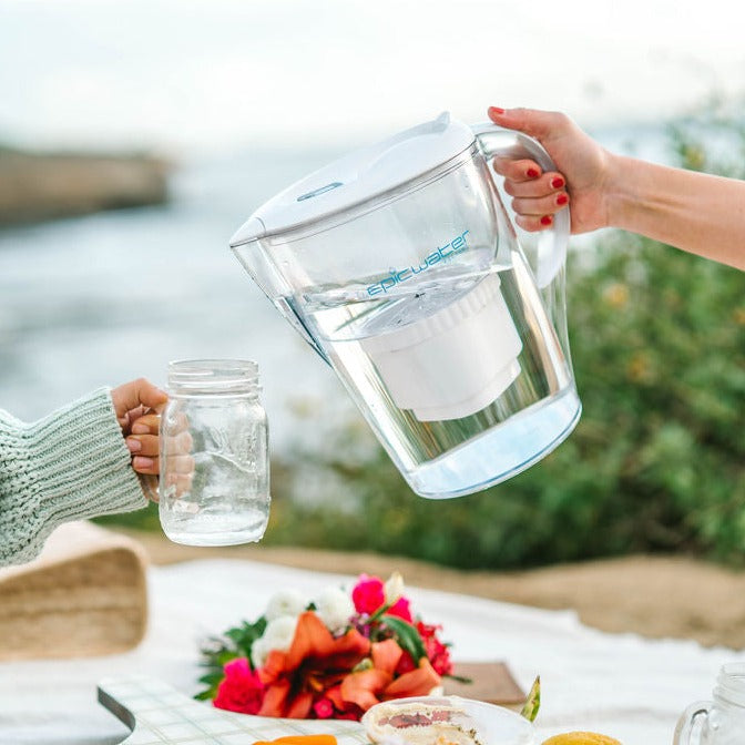 a person holding a picher of water that says Epic Water on it 